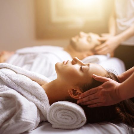 Young couple receiving head massage at beauty spa